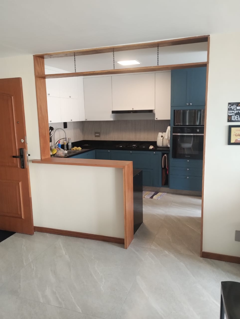 Cozinha planejada em azul com moldura em madeira